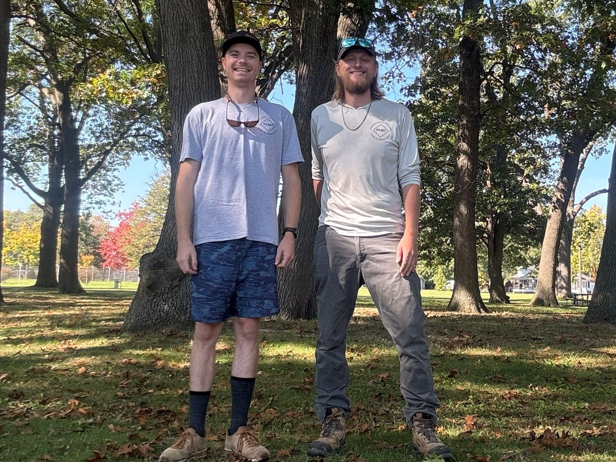 Tyler W. and Mitchell O., the owners of Precision Landscape & Hardscape, standing under large oak trees